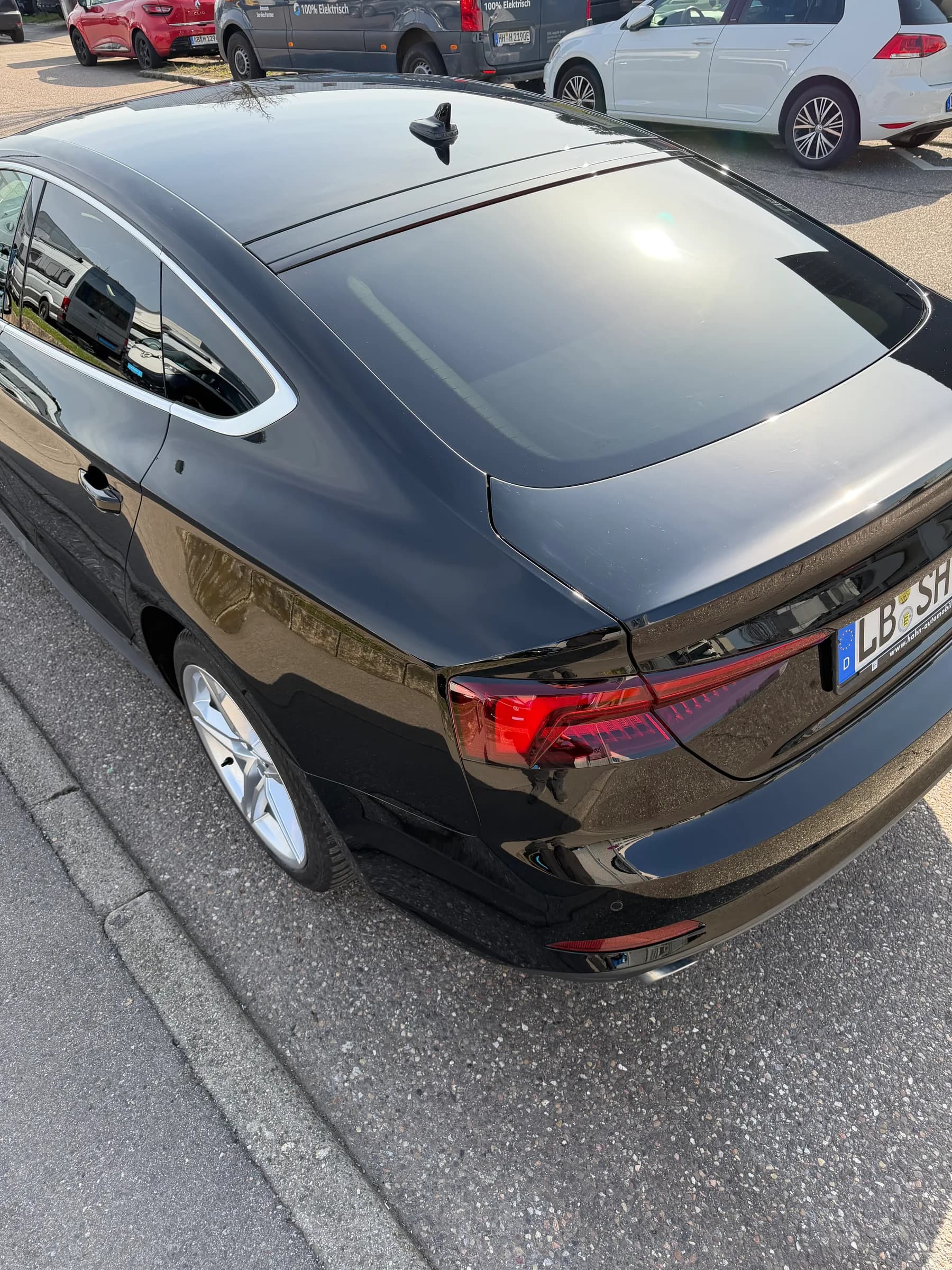 Schwarzer Audi A5 Sportback von schräg hinten, Dach und Heckklappe mit gleichmäßigem Glanz.