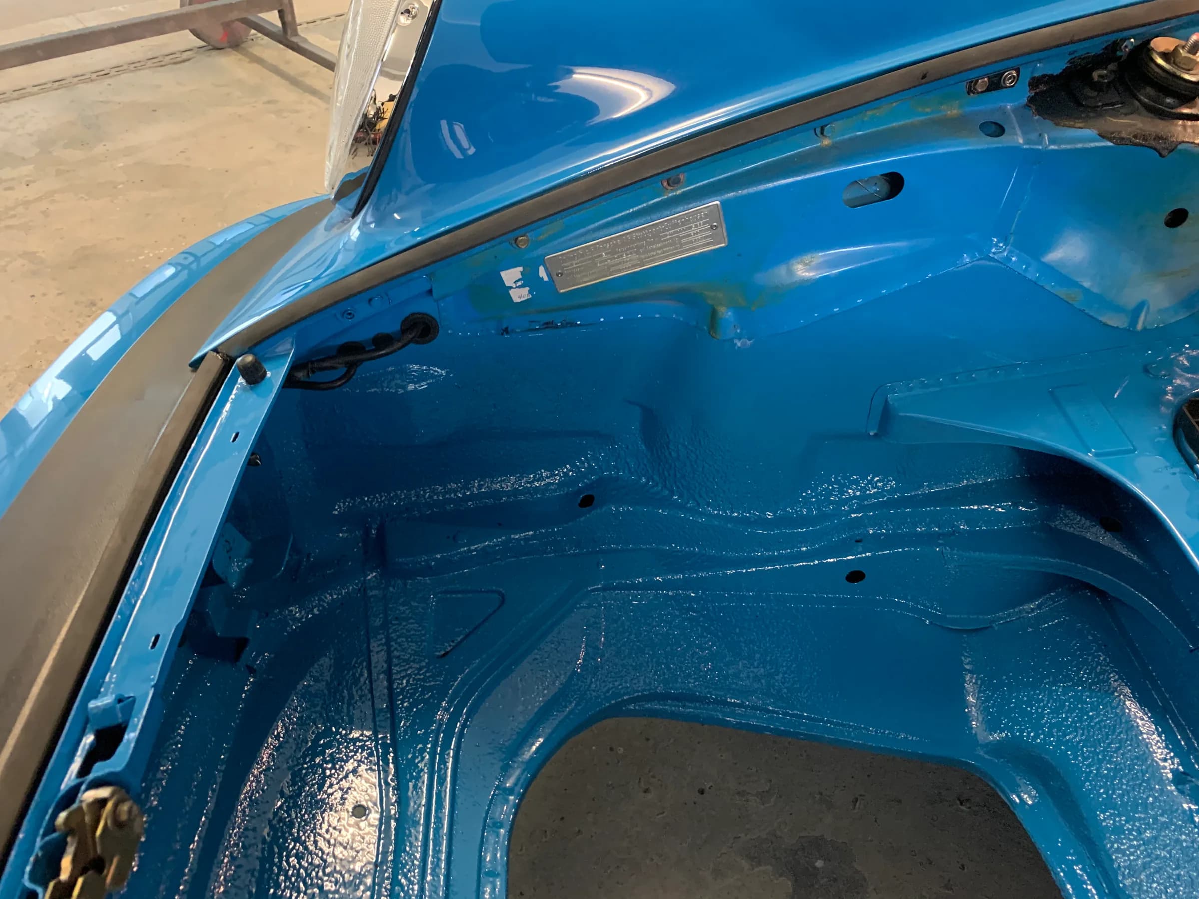 Motorraum eines Dodge Coronet, vollständig ausgeräumt und im türkisfarbenen Wagenfarbton lackiert.