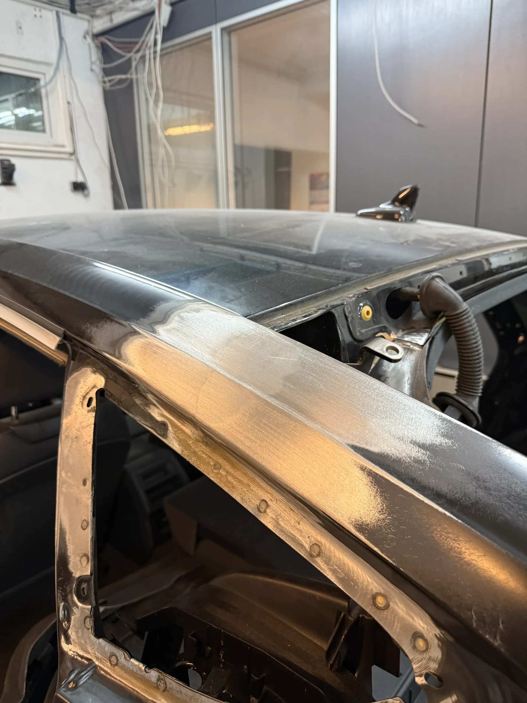 A-Säule und Dachkante eines Fahrzeugs, blank bis aufs nackte Metall geschliffen.