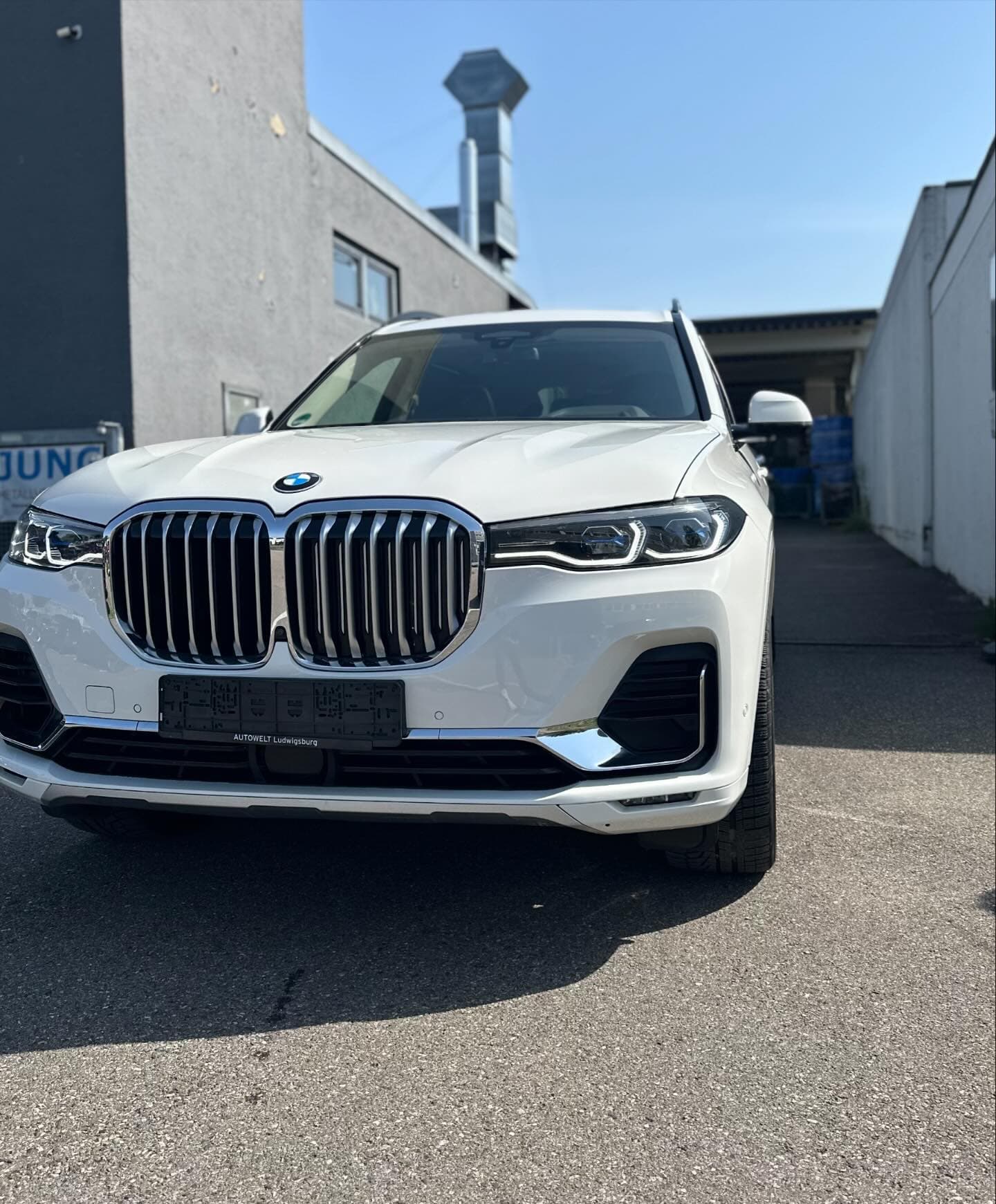 Weißer BMW X7 in der Frontansicht vor der Werkstatt