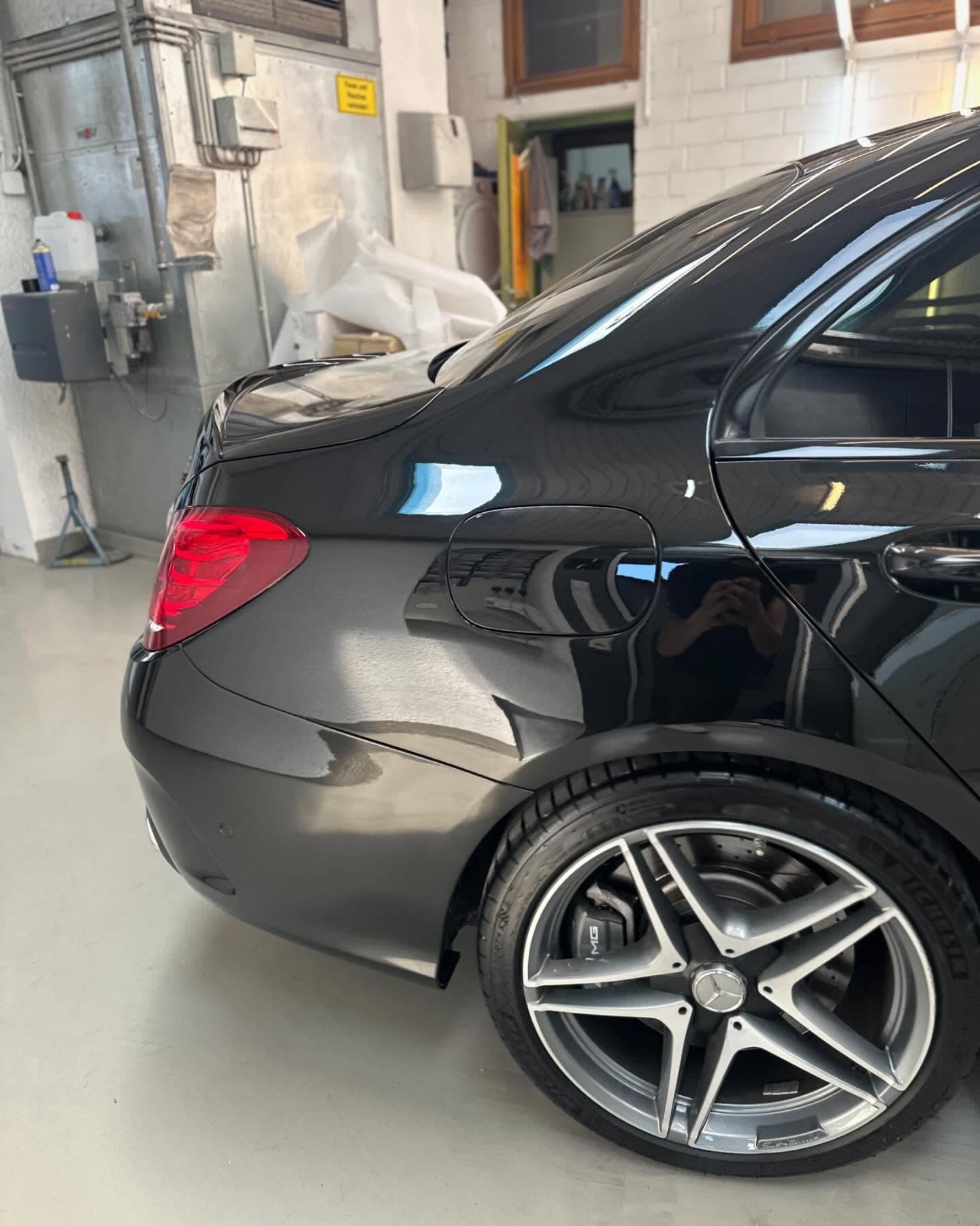 Instandgesetztes schwarzes AMG-Coupé in der Werkstatthalle