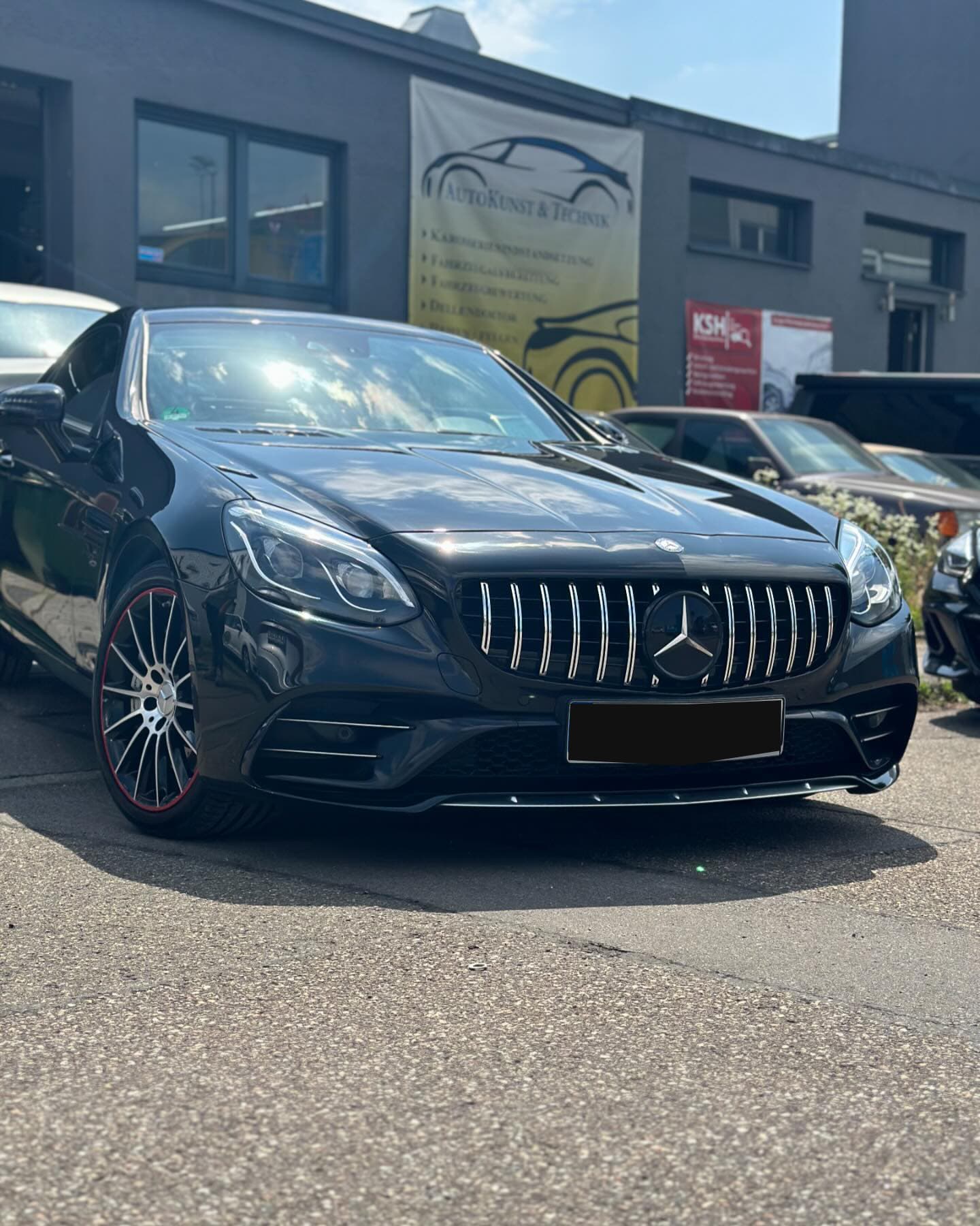 Schwarzer Mercedes-AMG SLC Roadster vor der Halle von Autokunst