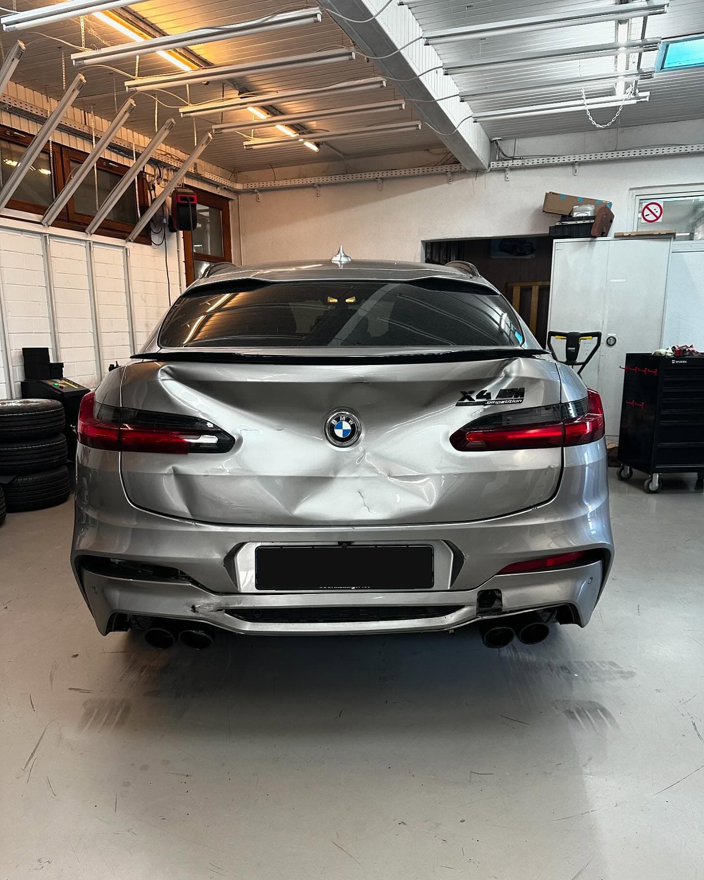 Heckansicht des BMW X4 M Competition in der Werkstatthalle